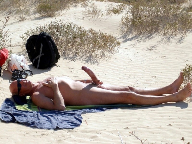 Naked guys sunbathe on the beach