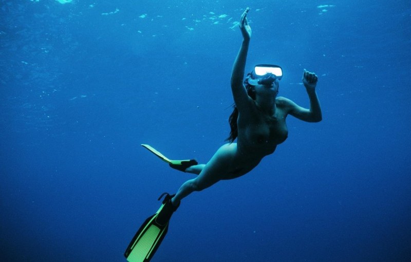 Naked women with flippers underwater