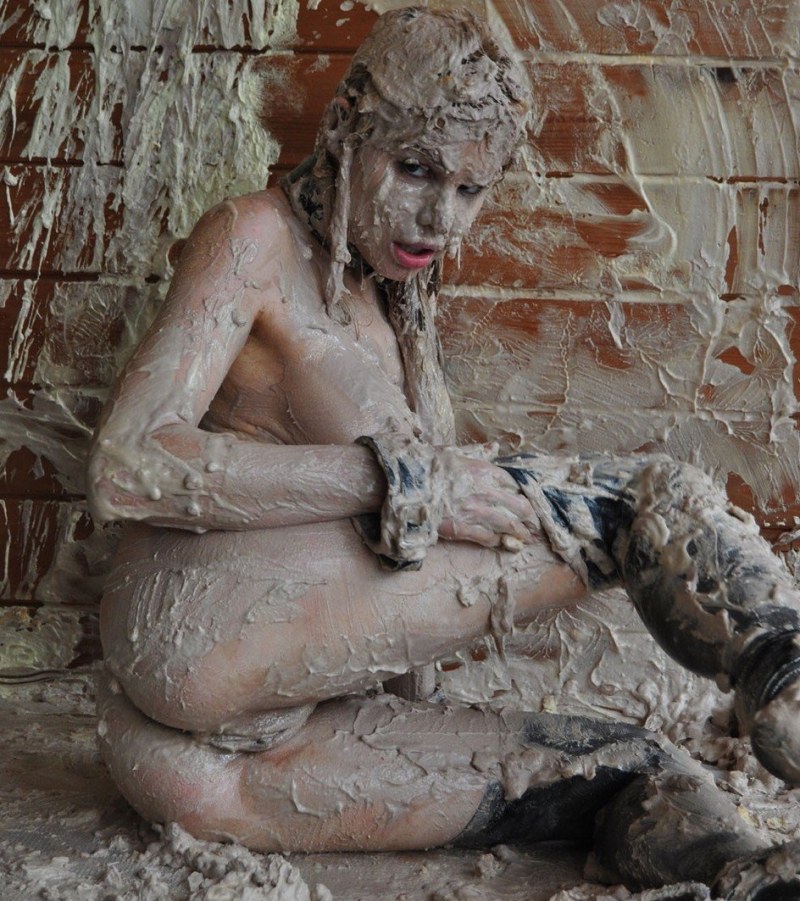 Naked women are lying in mud