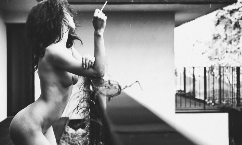 Naga girl smokes on the balcony