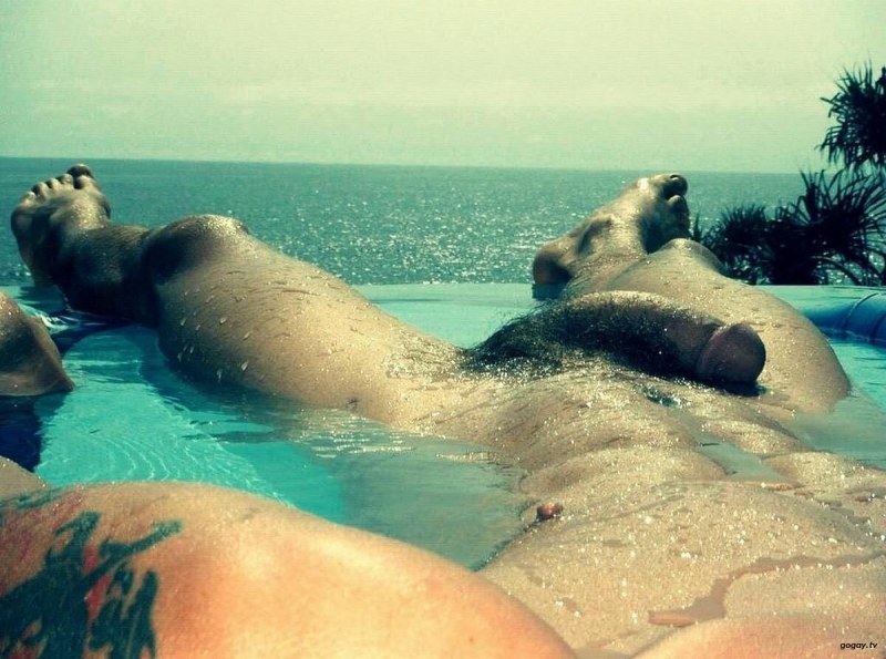 A naked guy lies on the beach