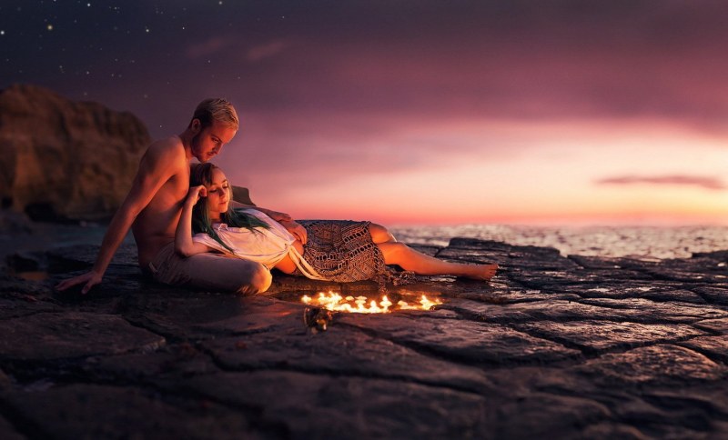 A couple on the seashore with a bonfire