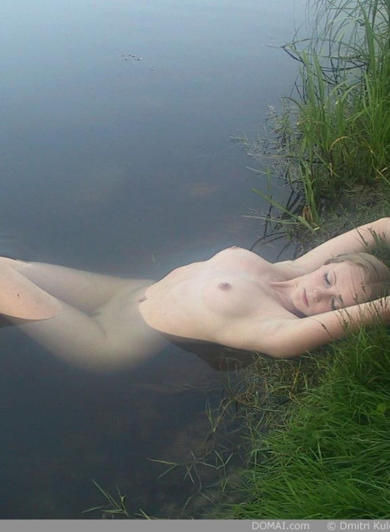 Undresses on the shore of the lake
