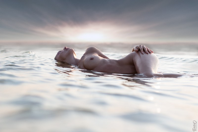 Naked female body in water