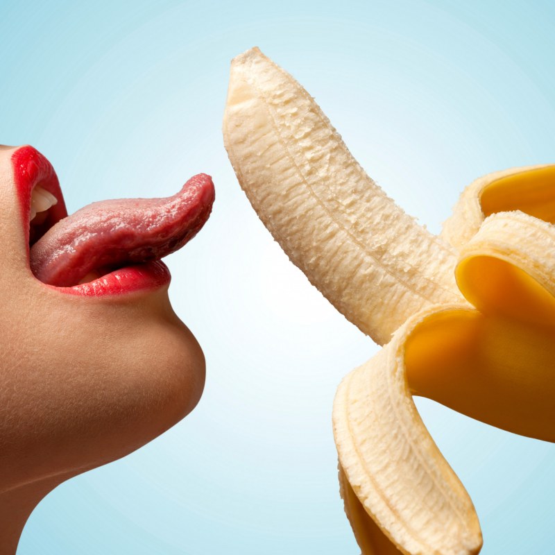 The girl licks the banana