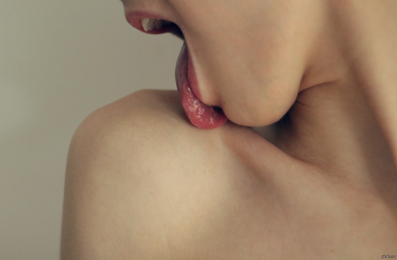 The girl licks her shoulder