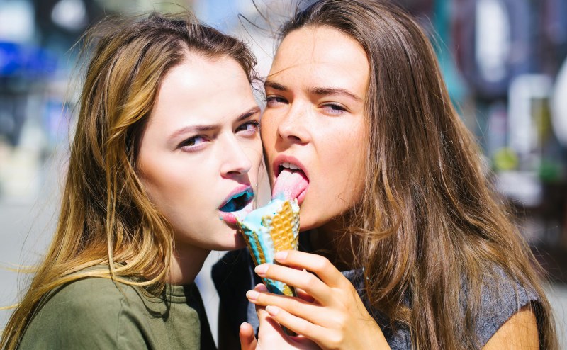 Two girls lick