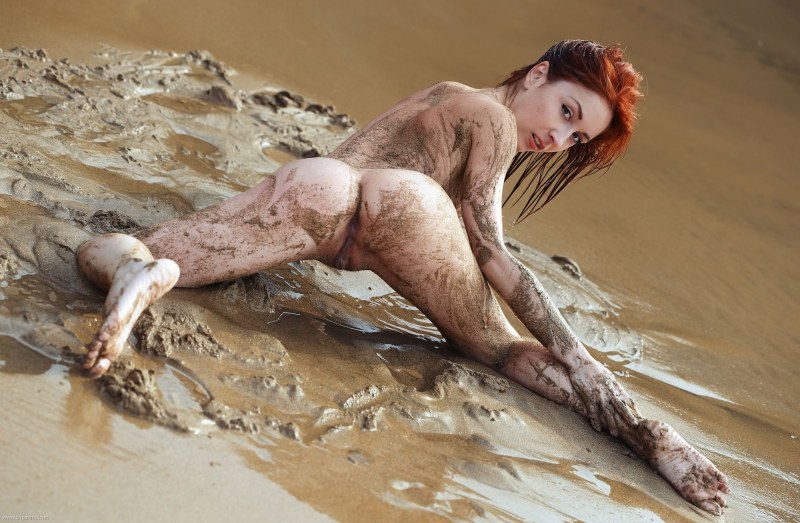 Naked women associated in mud