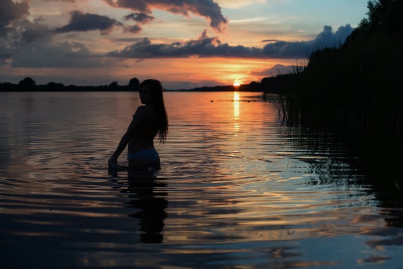 Girl at sunset by the lake