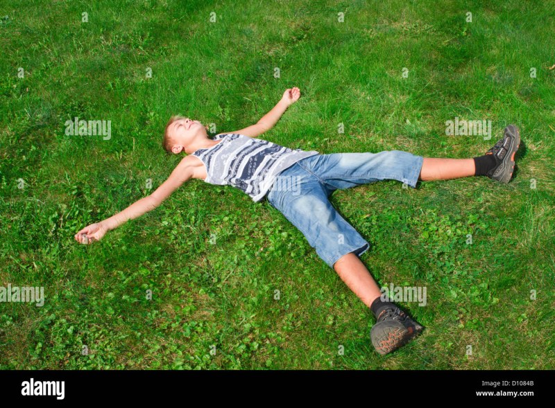 The girl lies on her back on the grass