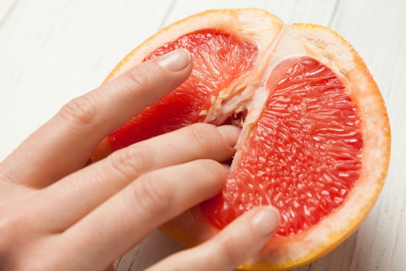Grapefruit in section with fingers